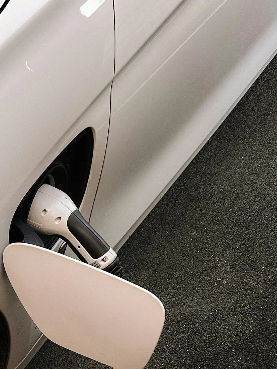White car charging, with the charging cable in the port