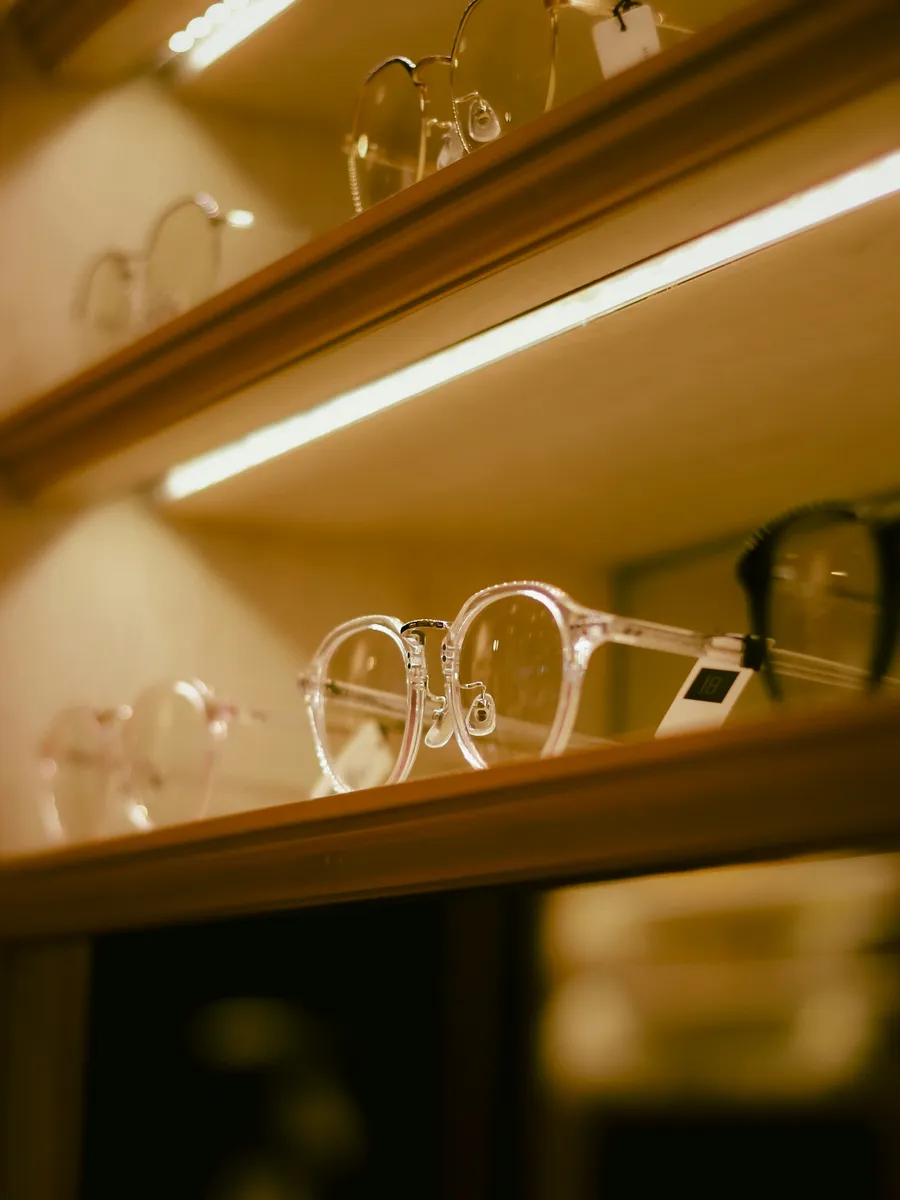 Glasses on a lit shelf at an optician